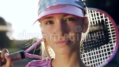 严肃的<strong>年轻</strong>女孩拿着<strong>网球拍</strong>看着镜头。